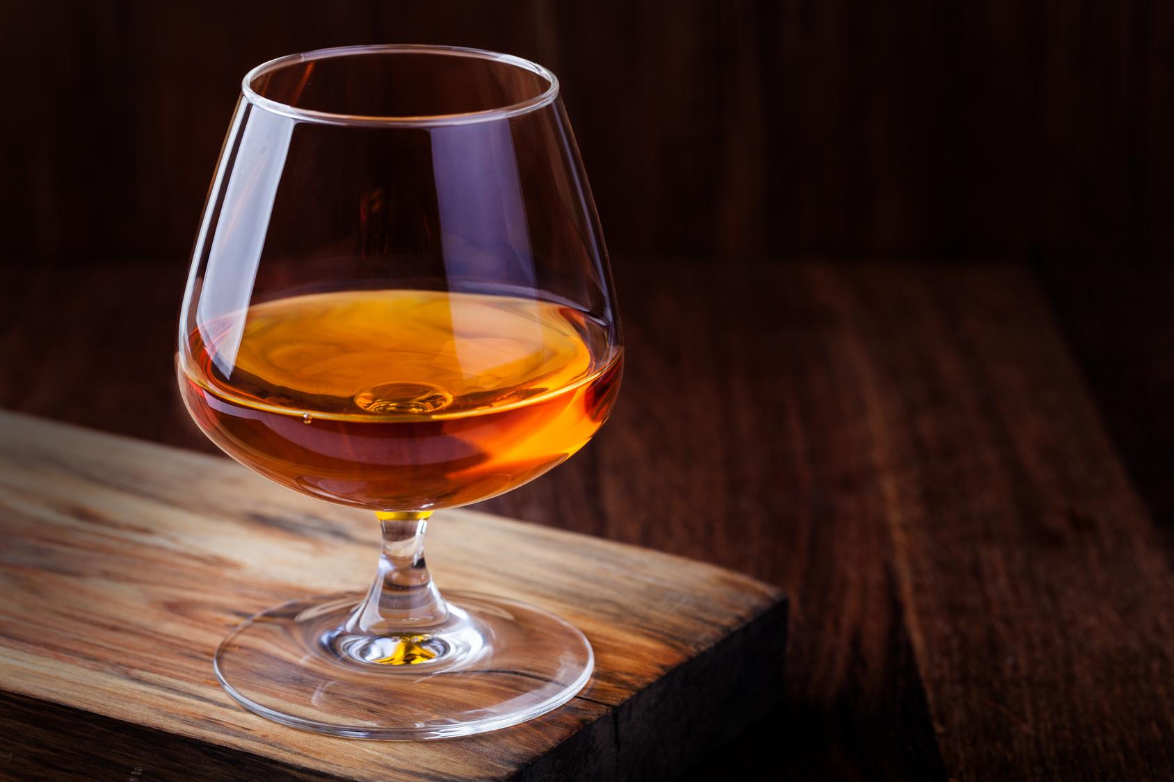 Glas Cognac auf hözernem Tisch