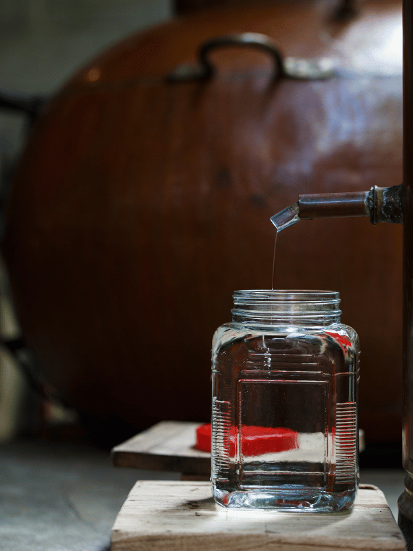 Rum wird aus einer Distillerie in ein Glas abgefüllt