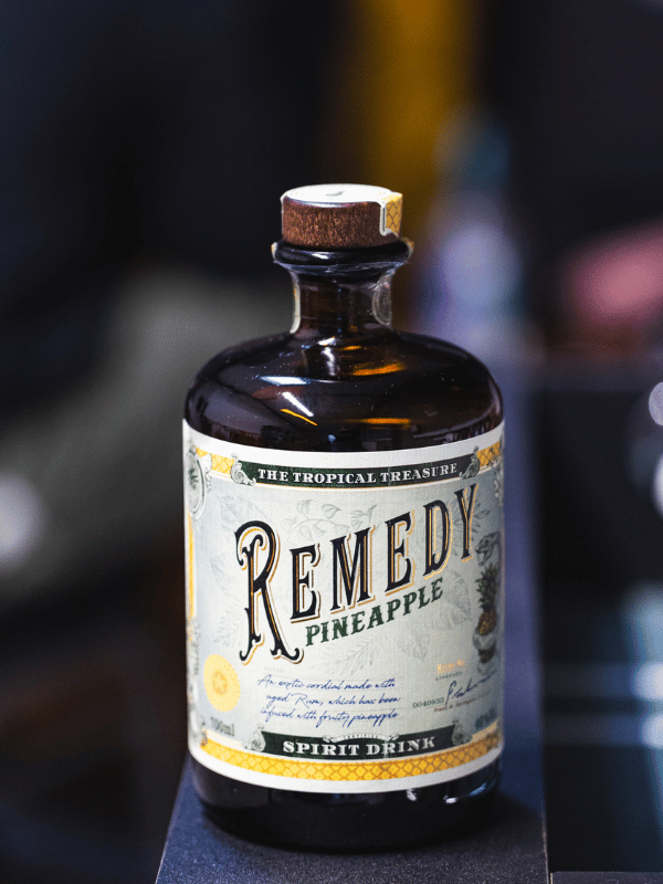 Remedy Pineapple Moodbild - Flasche steht auf einem Geländer