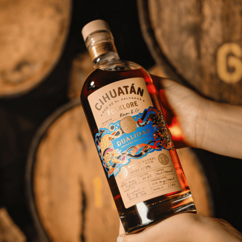 Ron Cihuatan Folklore Dualidad Single Barrel Rum Rum & Co Edition - Moodbild, Flasche über Fässern