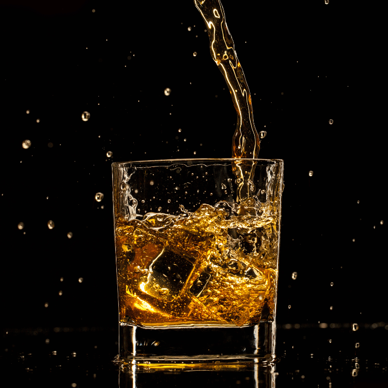 Whiskyglas Moodbild - Eiswürfel im Glas und Whisky wird eingeschenkt