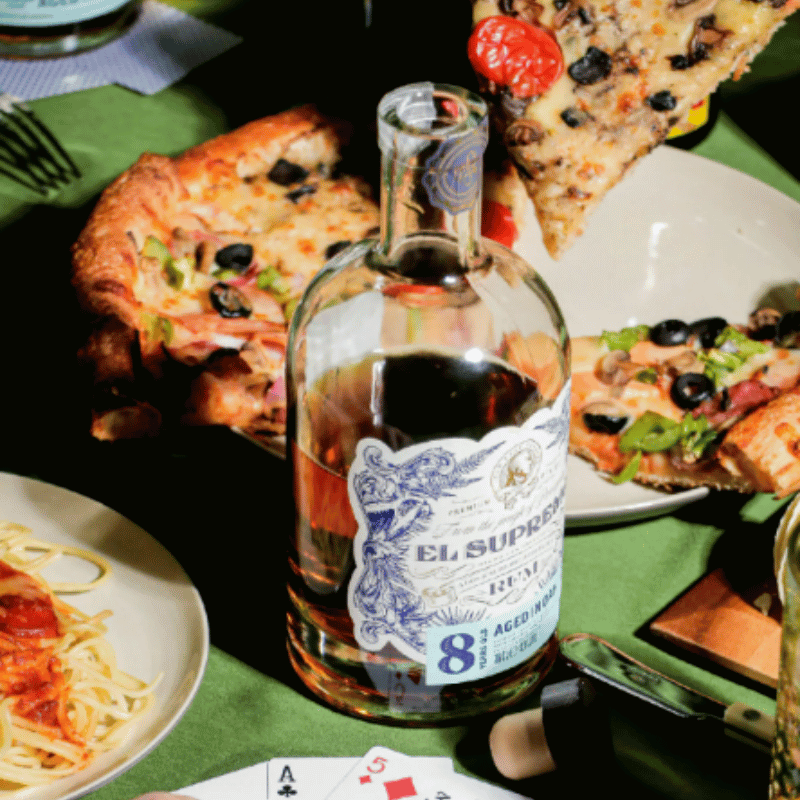 El Supremo Premium Rum Moodbild - 8 Jahre steht zwischen Pizzatellern
