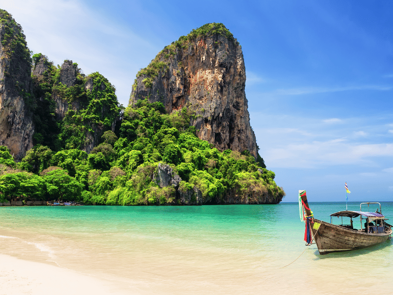 Thailand Moodbild - Ein Stand mit Boot im Wasser und kleinem Berg im Hintergrung