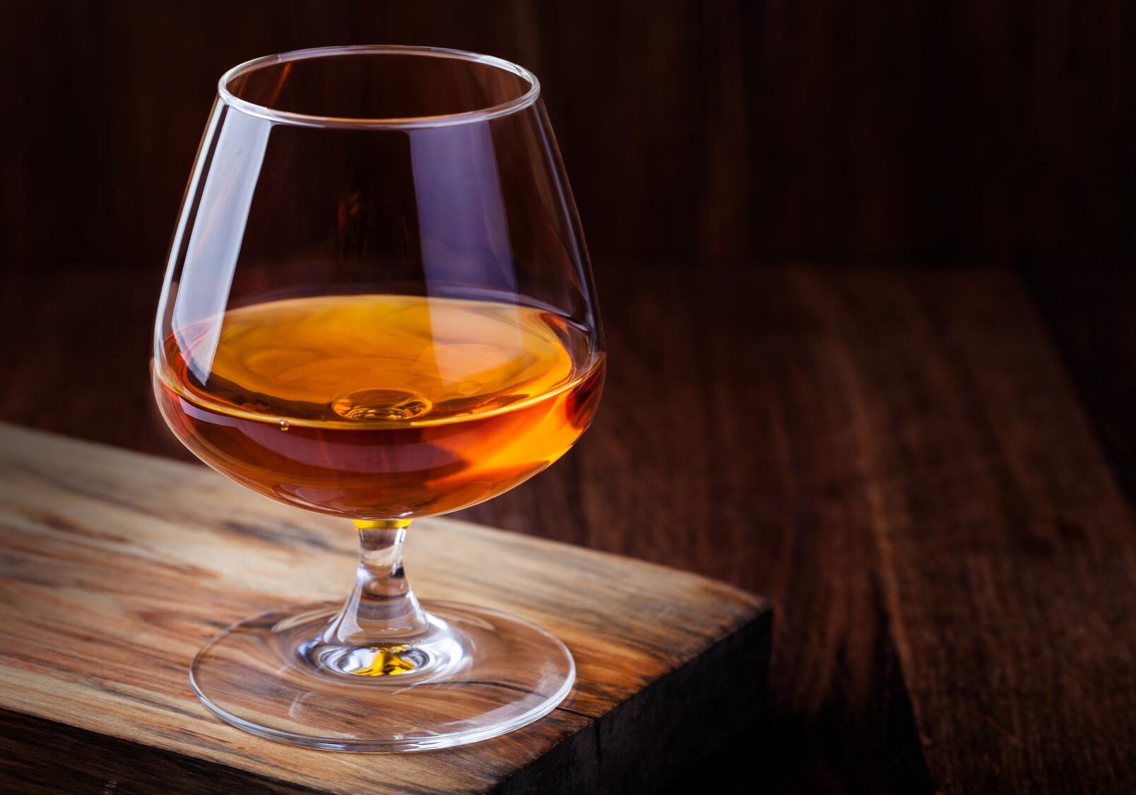 Glas Cognac auf hözernem Tisch